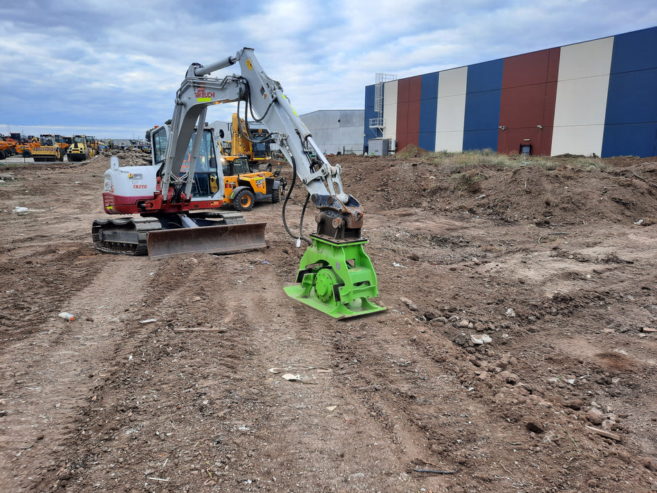 Takeuchi TB290 excavator fitted with an Impact hydraulic compaction plate, ideal for compacting soil in construction and earthmoving projects. This equipment setup ensures effective soil stabilization, enhancing site preparation efficiency