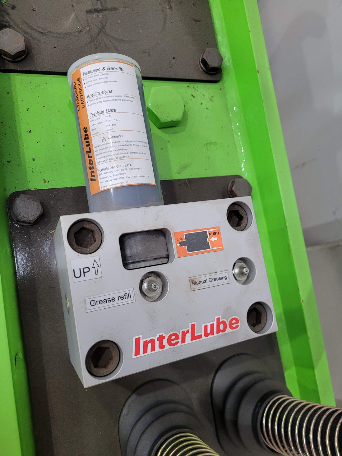 Close-up view of an InterLube grease refill system installed on heavy machinery, designed for automated lubrication and maintenance of equipment components.