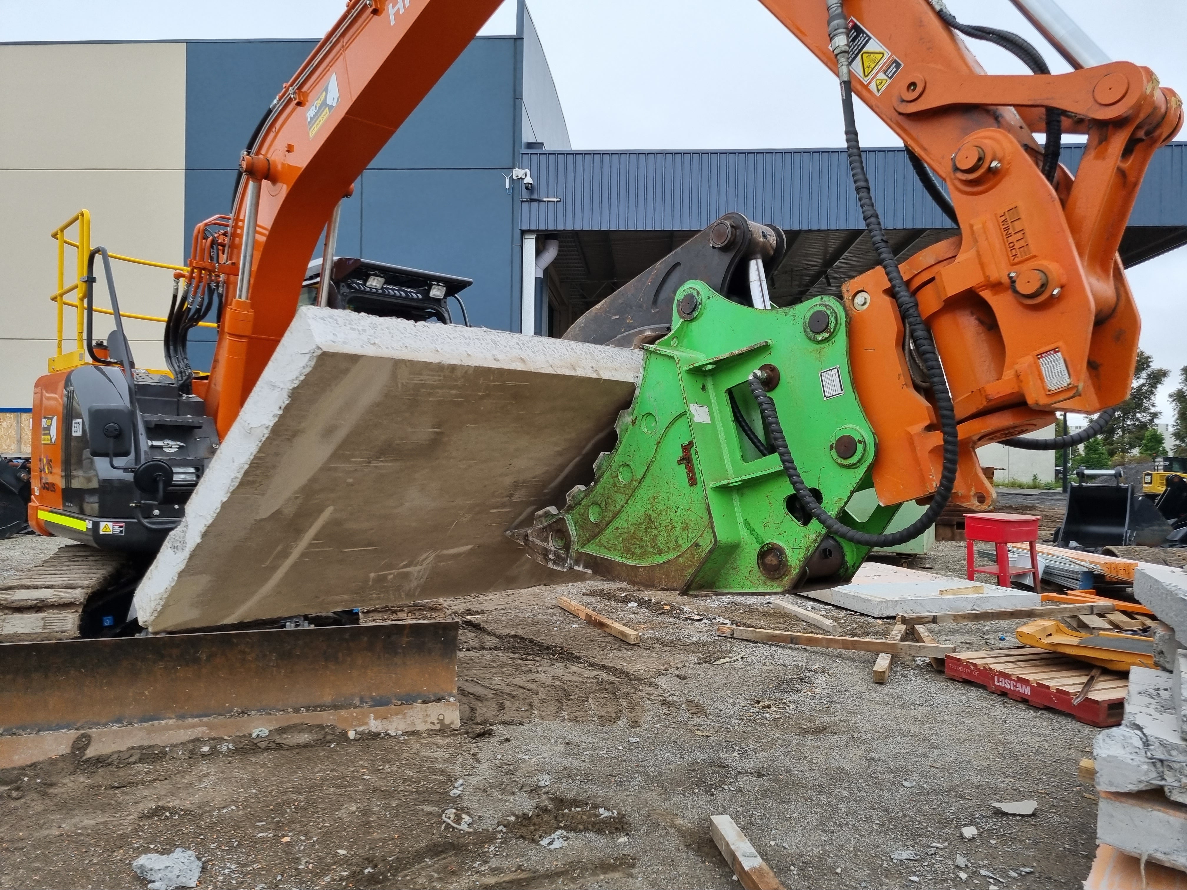 Impact brand heavy-duty grapple bucket attachment mounted on a Volvo excavator, designed for efficient material handling, demolition, and clearing tasks. The robust construction and powerful gripping capability of this grapple bucket make it ideal for various construction, forestry, and recycling applications, enhancing operational productivity and precision."