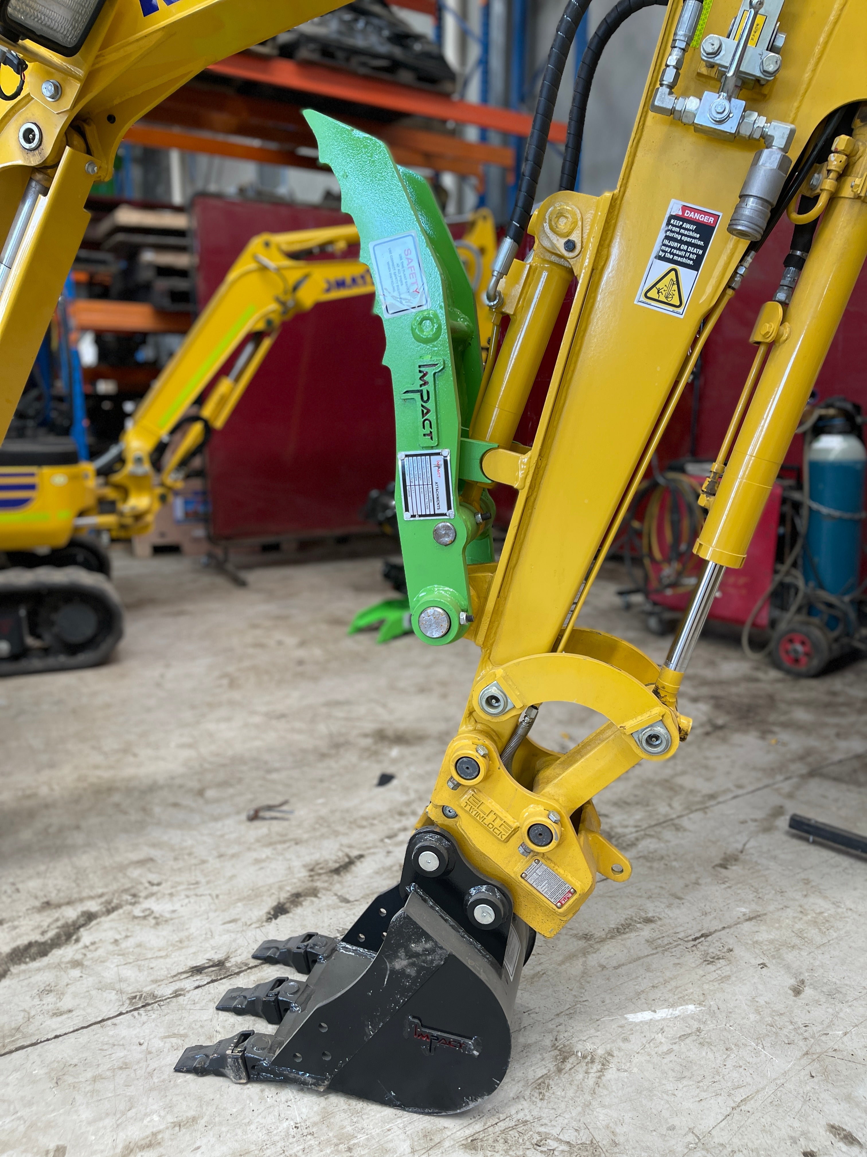 Yellow excavator equipped with an Impact hydraulic thumb attachment, designed for enhanced material handling and precision in excavation tasks, featuring high durability and easy installation.
