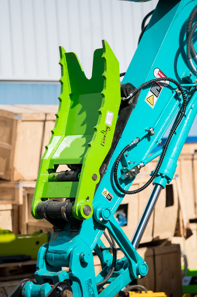 Excavator fitted with an Impact hydraulic thumb attachment, enhancing grip and control for material handling and demolition tasks.