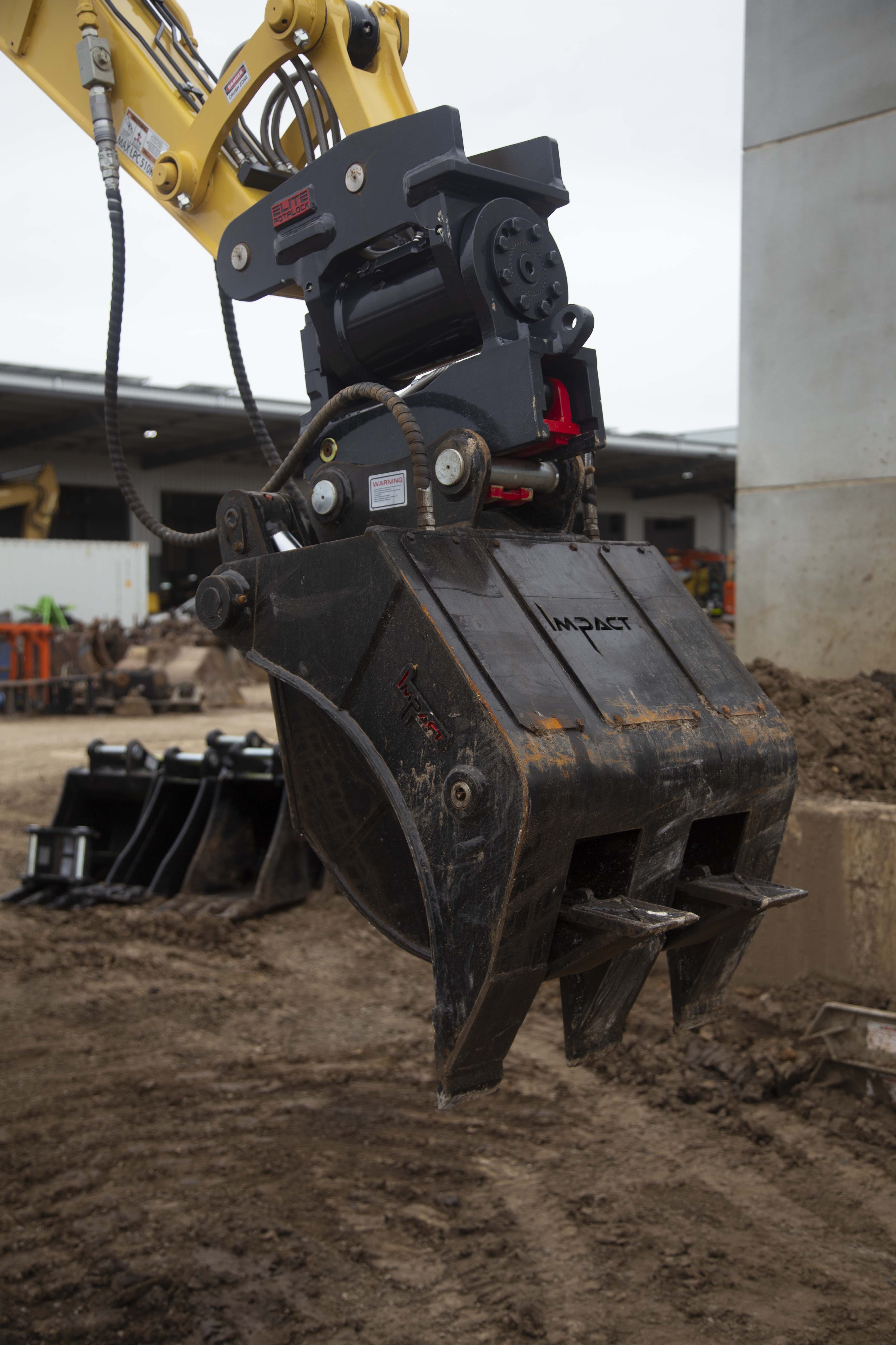 This image features an Impact brand five-finger grab attachment mounted on an excavator, designed for heavy-duty material handling tasks in construction and demolition projects. The close-up view highlights the grab's durable construction, making it ideal for efficiently sorting, lifting, and moving various materials, including debris, timber, and scrap metal. This attachment enhances the excavator's versatility and productivity in challenging work environments.
