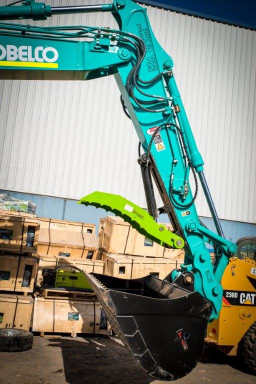 Excavator fitted with an Impact hydraulic thumb attachment, enhancing grip and control for material handling and demolition tasks.