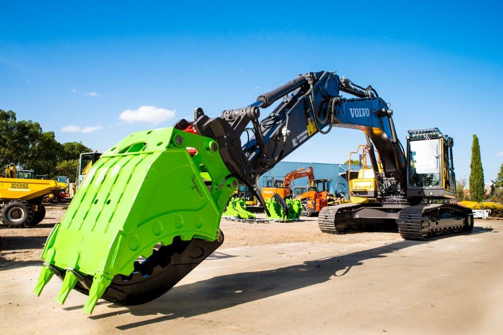 Impact brand heavy-duty grapple bucket attachment mounted on a Volvo excavator, designed for efficient material handling, demolition, and clearing tasks. The robust construction and powerful gripping capability of this grapple bucket make it ideal for various construction, forestry, and recycling applications, enhancing operational productivity and precision."