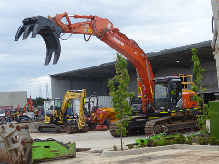 This image features a Hitachi excavator equipped with a five-finger grab attachment, ideal for handling and moving large materials in construction and demolition projects. The powerful and versatile attachment enhances the efficiency of the excavator, making it suitable for various heavy-duty tasks on the job site.