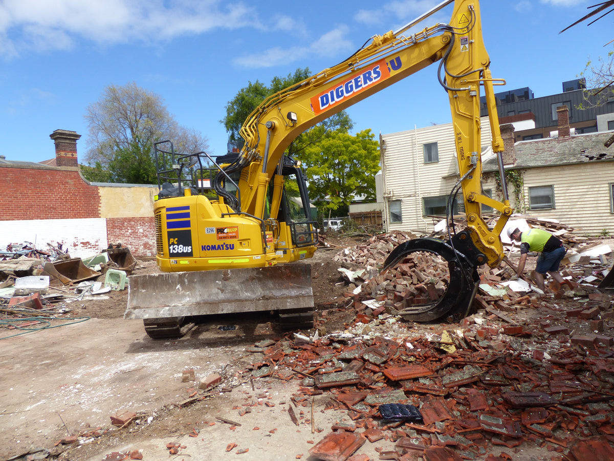 This image displays a close-up of a five-finger grab attachment on an excavator, efficiently handling debris at a construction site. The robust grab is ideal for sorting, picking, and moving heavy materials such as bricks and demolition waste, enhancing the productivity and versatility of the excavator in various construction and demolition applications.