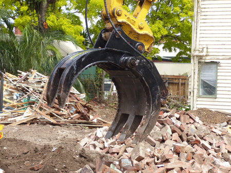 This image displays a close-up of a five-finger grab attachment on an excavator, efficiently handling debris at a construction site. The robust grab is ideal for sorting, picking, and moving heavy materials such as bricks and demolition waste, enhancing the productivity and versatility of the excavator in various construction and demolition applications.