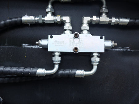 Close-up view of an Impact 4 in 1 bucket attachment on a track loader/skid steer, highlighting the heavy-duty construction and branding, ideal for various excavation and material handling tasks in construction