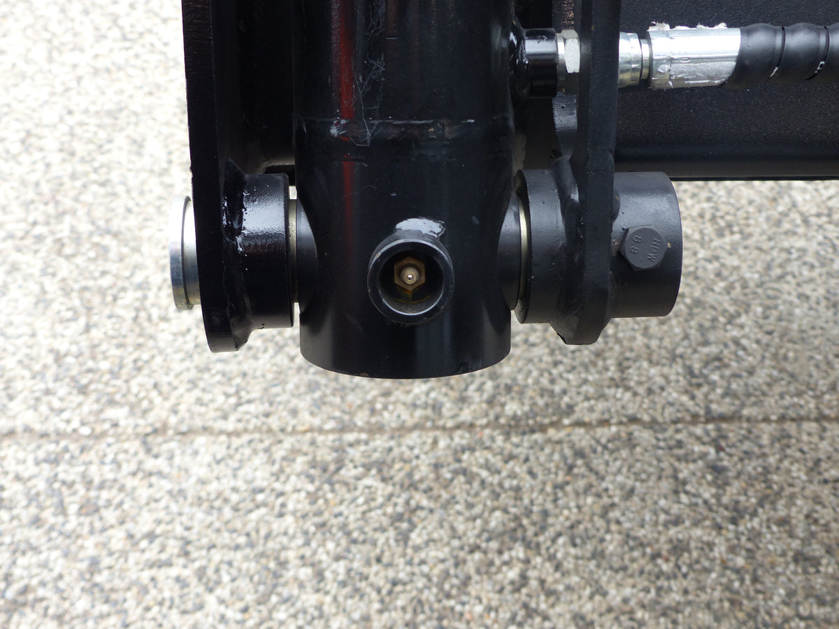 Close-up view of an Impact 4 in 1 bucket attachment on a track loader/skid steer, highlighting the heavy-duty construction and branding, ideal for various excavation and material handling tasks in construction