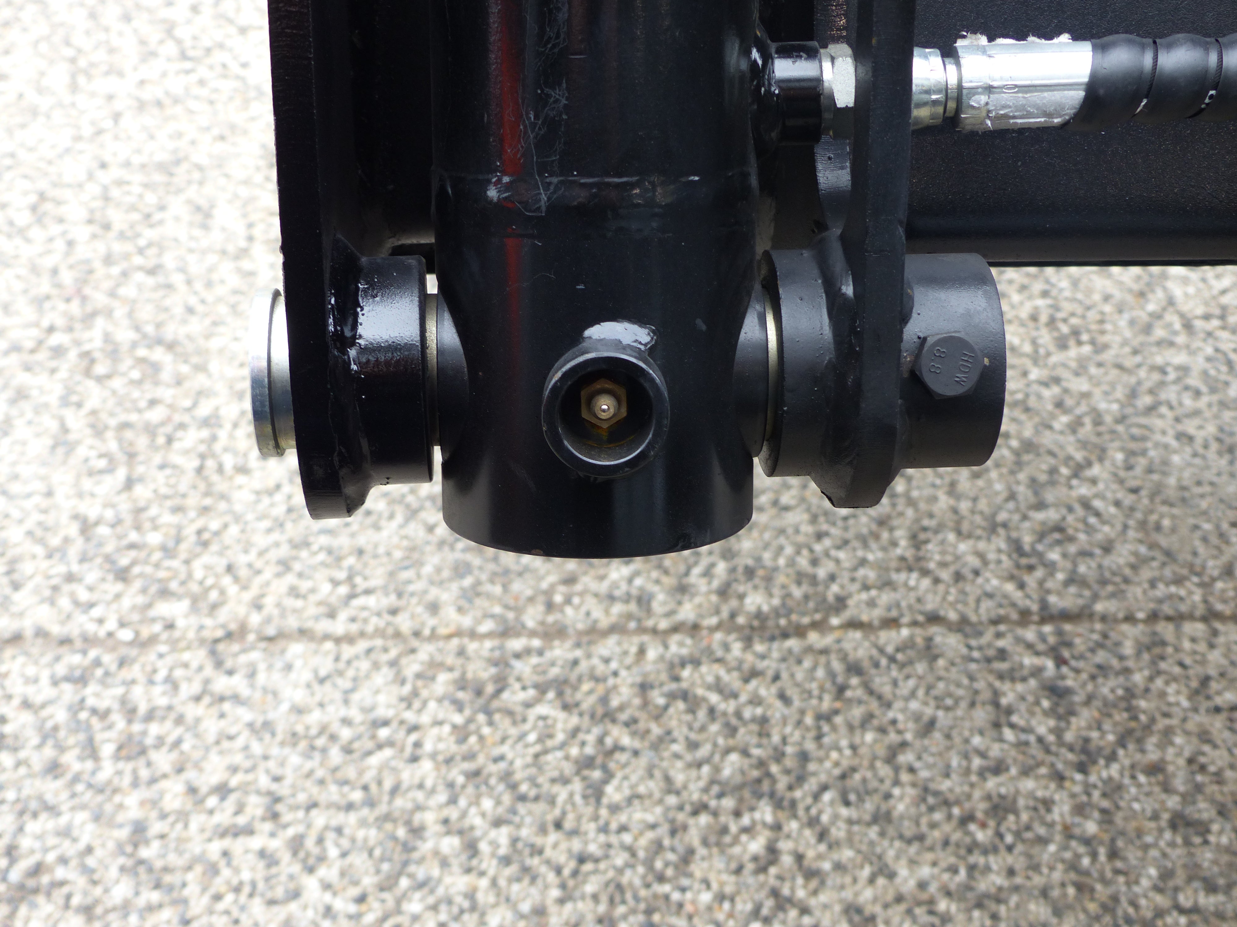 Close-up view of an Impact 4 in 1 bucket attachment on a track loader/skid steer, highlighting the heavy-duty construction and branding, ideal for various excavation and material handling tasks in construction