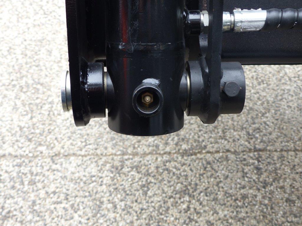 Close-up view of an Impact 4 in 1 bucket attachment on a track loader/skid steer, highlighting the heavy-duty construction and branding, ideal for various excavation and material handling tasks in construction