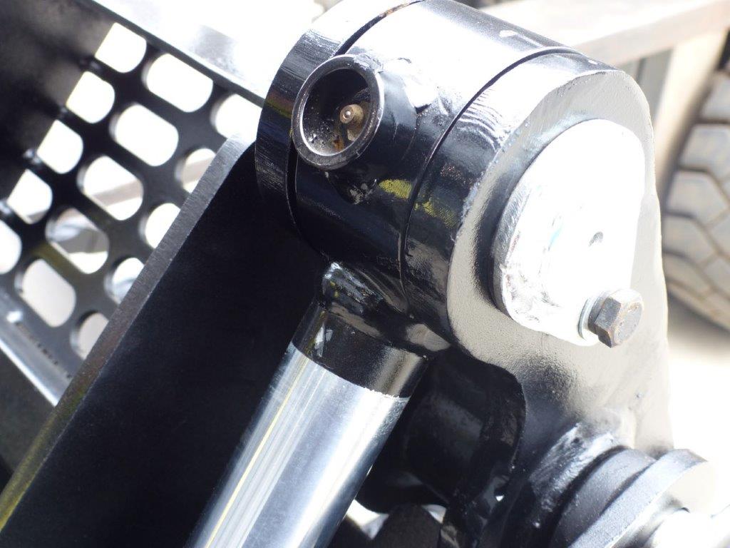 Close-up view of an Impact 4 in 1 bucket attachment on a track loader/skid steer, highlighting the heavy-duty construction and branding, ideal for various excavation and material handling tasks in construction.