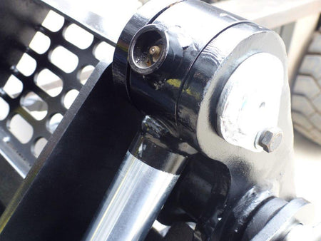 Close-up view of an Impact 4 in 1 bucket attachment on a track loader/skid steer, highlighting the heavy-duty construction and branding, ideal for various excavation and material handling tasks in construction.