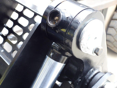Close-up view of an Impact 4 in 1 bucket attachment on a track loader/skid steer, highlighting the heavy-duty construction and branding, ideal for various excavation and material handling tasks in construction
