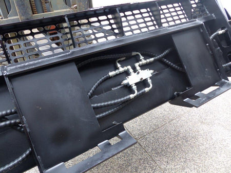 Close-up view of an Impact 4 in 1 bucket attachment on a track loader/skid steer, highlighting the heavy-duty construction and branding, ideal for various excavation and material handling tasks in construction.