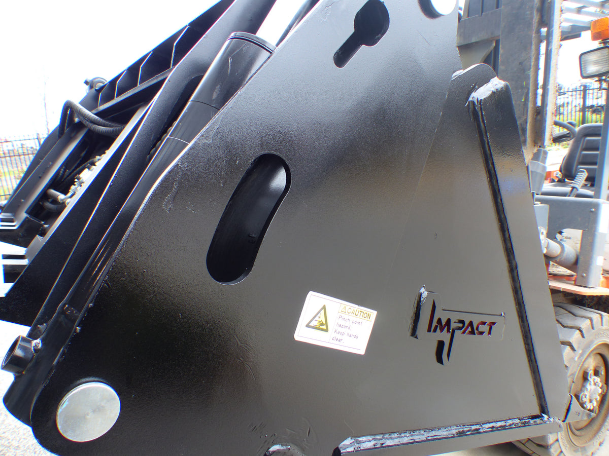 Close-up view of an Impact 4 in 1 bucket attachment on a track loader/skid steer, highlighting the heavy-duty construction and branding, ideal for various excavation and material handling tasks in construction