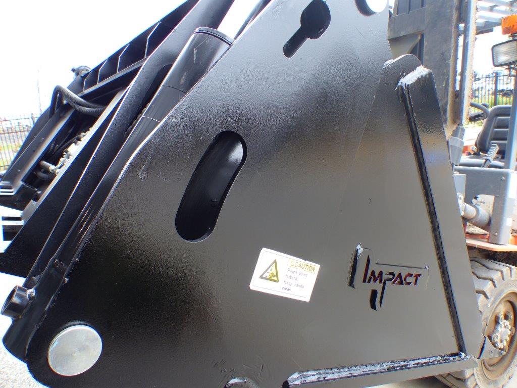 Close-up view of an Impact 4 in 1 bucket attachment on a track loader/skid steer, highlighting the heavy-duty construction and branding, ideal for various excavation and material handling tasks in construction.