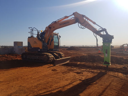Hyundai R125 excavator using an Impact Attachments hydraulic breaker for excavation work on a construction site