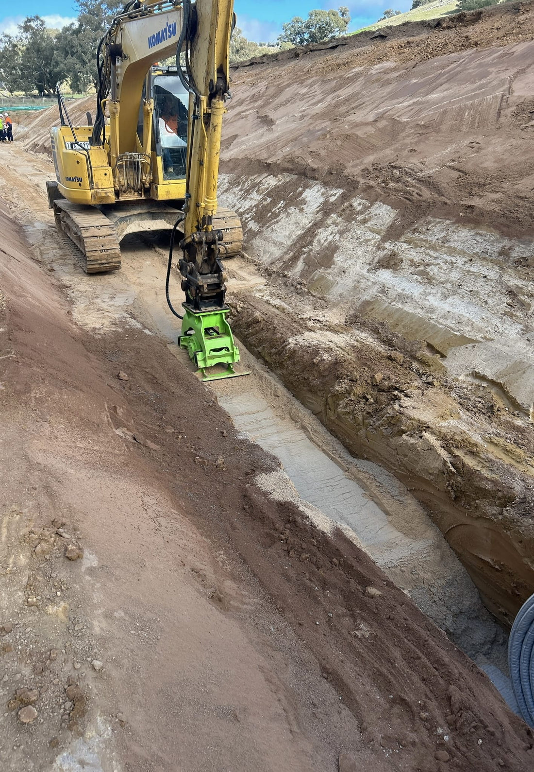Komatsu excavator operated by Tweed Civil, equipped with an Impact hydraulic compaction plate, used for efficient soil compaction in large-scale earthmoving projects. This combination ensures optimal ground preparation and site stabilization